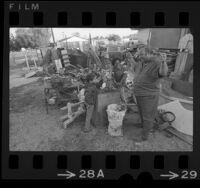 Barney Mull with two children at his Young People of Watts Improvement Center, mower repair yard in Watts, Calif., 1971