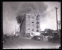 Firefighters on ladder fighting fire on 5th floor of Newmark Bros. building, Los Angeles, 1928