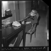 Gloria Steinem on the telephone giving a radio interview at the Beverly Hills Hotel, 1972