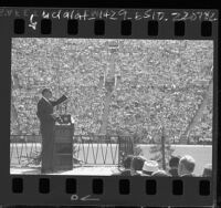 Evangelist Billy Graham speaking to crowd Los Angeles Memorial Coliseum, 1963