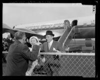 MGM film director George Cukor, greeting Laurence Olivier and his wife actress Vivien Leigh at airport in Los Angeles, Calif., 1957