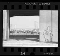 Outline of human figure with writing "Lost Angeles" on column at homeless camp in Los Angeles, Calif., 1987