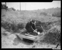 Law enforcement official with the Mary Skeele kidnapping case reading a note at a curbside field, 1933