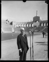 Joseph Scott speaks into a microphone on the field of the Memorial Coliseum, Los Angeles, 1930s