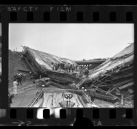 Emergency and construction workers on collapsed bridge on the San Bernardino and San Gabriel River Freeways, Los Angeles, 1970