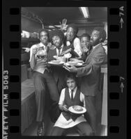 Los Angeles based music group, the BusBoys posing in a kitchen, 1980