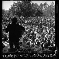 Silhouette of folk singer Phil Ochs on stage during Vietnam War moratorium event at Valley State College in Northridge, Calif., 1969