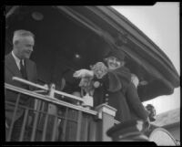 President Herbert Hoover standing on the back of a railroad car with first Lady Lou Henry Roosevelt holding a lion cub, El Monte, 1932