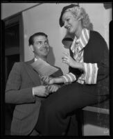 Actor John Quillan smiles at his soon-to-be wife, actress Anita Thompson who holds their marriage license, Los Angeles, 1935