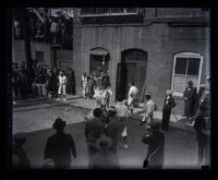 Crowd outside building watching Chinese performers in the Dragon Dance, Los Angeles, 1929