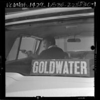 Policeman DeWayne Anderson reenacting altercation with two men who demanded he remove Goldwater sticker from car, Calif., 1964