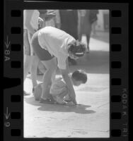 Woman and little girl examining hand imprints at Grauman's Chinese Theater, Hollywood (Los Angeles), 1965