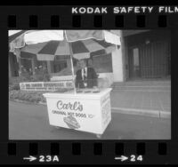 Carl Karcher, founder of Carl's Jr., standing at hot dog cart in front of Karcher headquarters in Anaheim, Calif., 1981