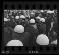 Police arrest protesters outside of Century Plaza during President Johnson's visit as reporters watch, 1967