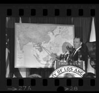 Los Angeles Mayor Samuel W. Yorty pointing at map during press conference about his Southeast Asia trip, 1965