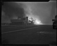 Structures on fire at Castle Rock Beach, Los Angeles, 1938