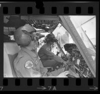 Two Los Angeles County Fire Department helicopter pilots demonstrating their night vision goggles, Calif., 1974