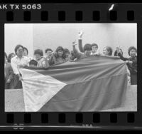 Filipinos holding flag of the Philippines during celebration of President Ferdinand E. Marcos' deposition Los Angeles, Calif., 1986