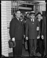 Clarence M. Fuller and Raymond W. McKee pose as they are escorted to prison, Los Angeles, about 1934