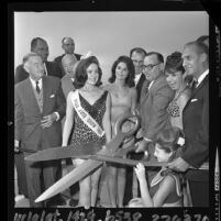 Edmund G. (Pat) Brown, surrounded by Robert E. McClure, beauty contestants and others, cutting ribbon at dedication of section of Santa Monica Freeway, 1964