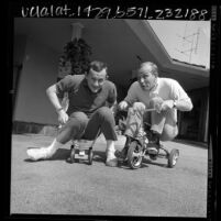 Dick and Tom Smothers playing about on tricycles, Los Angeles, Calif., 1966