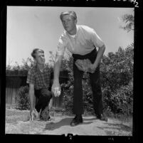 Taft High School baseball player Larry Dierker winding up pitch as his brother Rick watches in Los Angeles, Calif., 1964