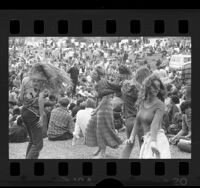 Four women dancing amongst crowd at an Easter Love In held at Elysian Park, Los Angeles, 1970