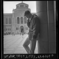 Jeff Smith, a pre-medical student, in reflective pose across from Powell Library on UCLA campus, 1966