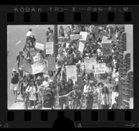 Demonstrators marching down street to commemorate 50th anniversary of women's suffrage in Los Angeles, Calif., 1970