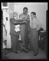 Boxing Inspector Bill Smith checks weight of Bantamweight Champion Harold Dade, Calif., 1947