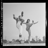 Los Angeles Ram's kicker Danny Villanueva in uniform doing the can-can with actress Susan Hart, 1964