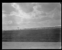 U.S. Army biplane releasing smoke screen during air show at United Airport in Burbank, 1930