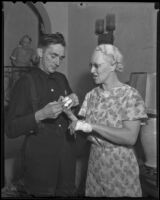 Fireman L. I. McCutcheon applies bandages to Mrs. Olive Byrne, Los Angeles, 1936