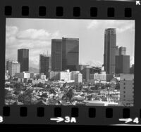 Cityscape of roof tops of houses with construction of high rise buildings in Los Angeles, Calif., 1973