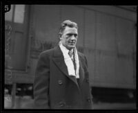 Football player Ernie Nevers in front of Southern Pacific train, California, 1930-1939 (?)