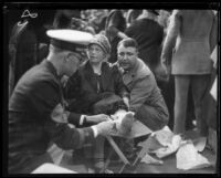 Woman wounded by the collapse of a Rose Parade grandstand receives first aid, Pasadena, 1926