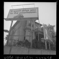 Two billboards in front yard of old house on Wilshire Blvd. in Los Angeles, Calif., 1966