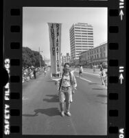 Man with banner reading "Justice Reparations Now!" during parade in Little Tokyo, Los Angeles, Calif., 1982