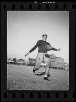 Bud Langley, USC football player, about to kick a football, Los Angeles, 1935