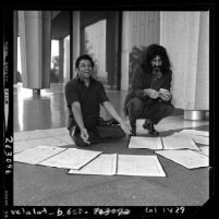 Conductor Zubin Mehta reviewing scores with musician Frank Zappa, 1970