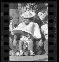 Raymundo Barillas with daughter Sandy wearing sombreros, watching East L.A. Christmas parade, Calif., 1986