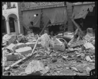 View of earthquake-damaged commercial buildings and a pile of building debris after the Long Beach earthquake, Southern California, 1933