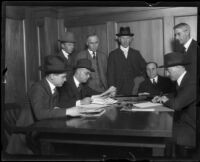 Attorneys, detectives, and others examining papers of murder victim Fay Sudow, 1920