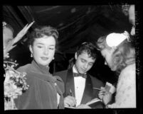 Actor Sal Mineo with actress Gigi Perreau signing autographs at the 1956 premiere of "The Man in the Gray Flannel Suit", Los Angeles, 1956