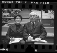 Chuck and Jean Weinstock, sports statisticians seated courtside in Los Angeles, Calif., 1973