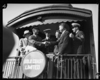 Commander Richard Byrd and his expedition members stand at the back of a train car, Los Angeles, 1928