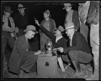 De Witt Nelson and others gathered around lantern outside during Ontario Fire, Los Angeles, 1935