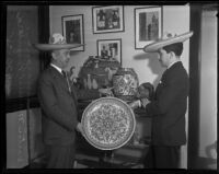 Mexican consul Joaquin Terrazas and Victor Manuel Pesqueira with plate and Mexican art, 1935