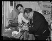 Dr. Ralph Willard, in the back, watching Dr. C. C. Warn search for signs of life in a frozen monkey, Los Angeles, 1935