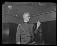 Police captain David L. Adams holds a badge, Los Angeles, [1923?]